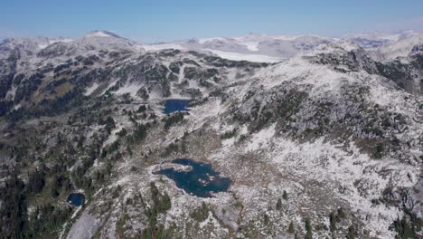 a view of a rugged alpine lake with a glacier in the background during british columbia's summer