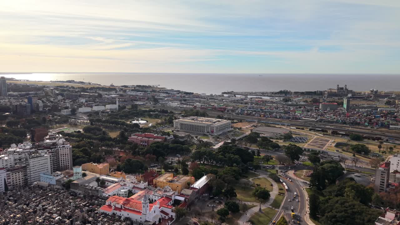 Forward-moving drone clip glides above Recoleta Cemetery and the adjacent University of Buenos Aires Law School during sunny afternoon
