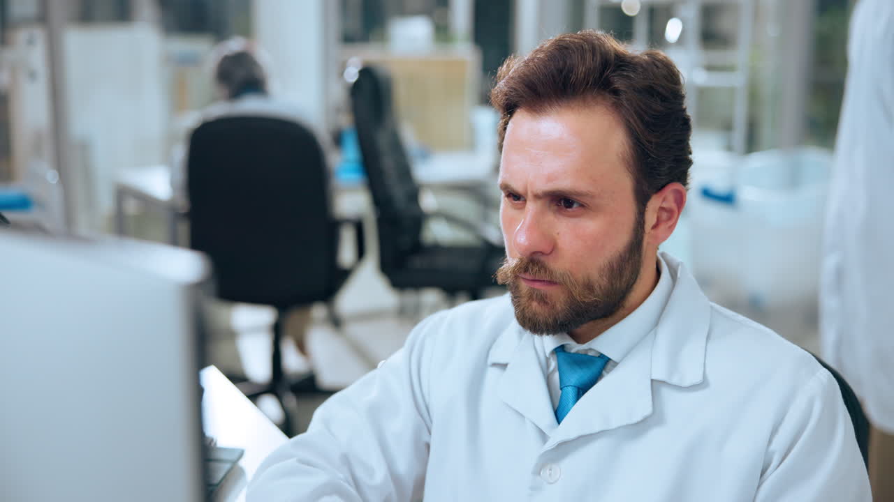 Scienziato concentrato al lavoro al computer in un laboratorio moderno