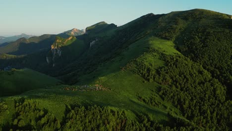 Aerial-push-in-tilt-down-over-camping-settlement-on-valley-saddle-at-sunset