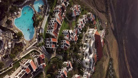 Imágenes-Verticales-Aéreas-Del-Resort-De-Lujo-Canario-Fuerteventura-Con-Piscina-En-La-Costa