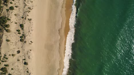 Vista-Aérea-Ascendente-De-Las-Olas-Del-Océano-Atlántico-Rodando-Sobre-La-Playa-De-Huelva-En-España