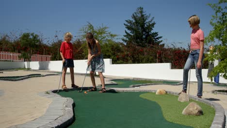 kids playing miniature golf in the garden 4k