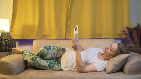 Woman reading a book while lying down.