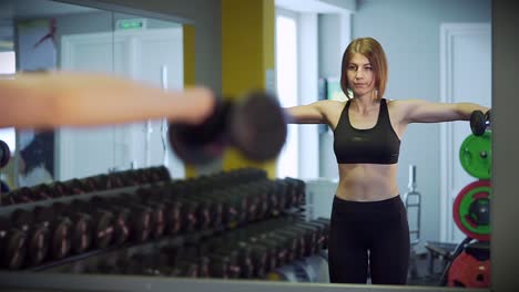 mujer trabajando con pesas en un gimnasio