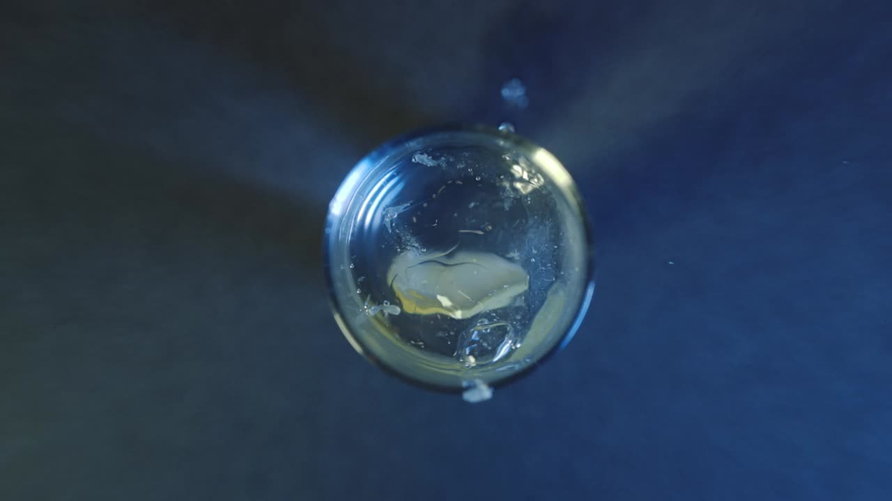 toma a cámara lenta de lima cayendo en una bebida