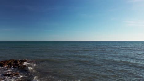 Antena-Moviéndose-Hacia-Atrás-Desde-El-Océano-Hacia-La-Playa-Lentamente