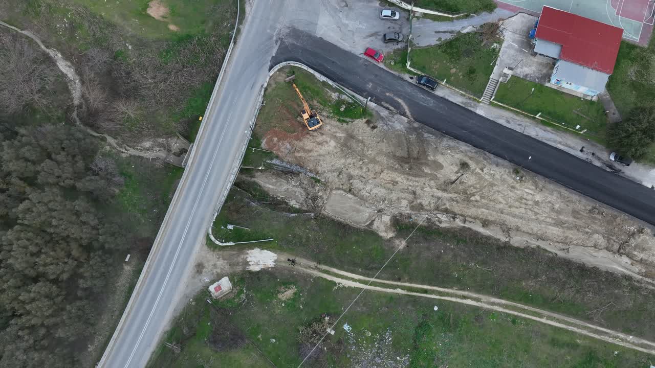 Excavator on the premises of a residential building construction site. Aerial drone overview