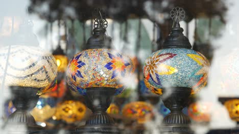 colourful turkish lamps from glass mosaic glowing. arabic multi colored authentic retro style lights. many illuminated moroccan craft lanterns. oriental islamic middle eastern decor. shiny folk shop