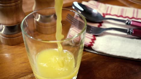 orange juice pouring into a glass, the morning breakfast. slow motion with rotation tracking shot.