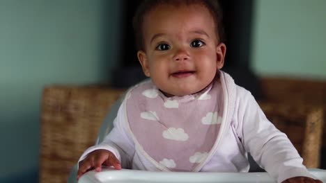 a baby very happy and joyful in a highchair