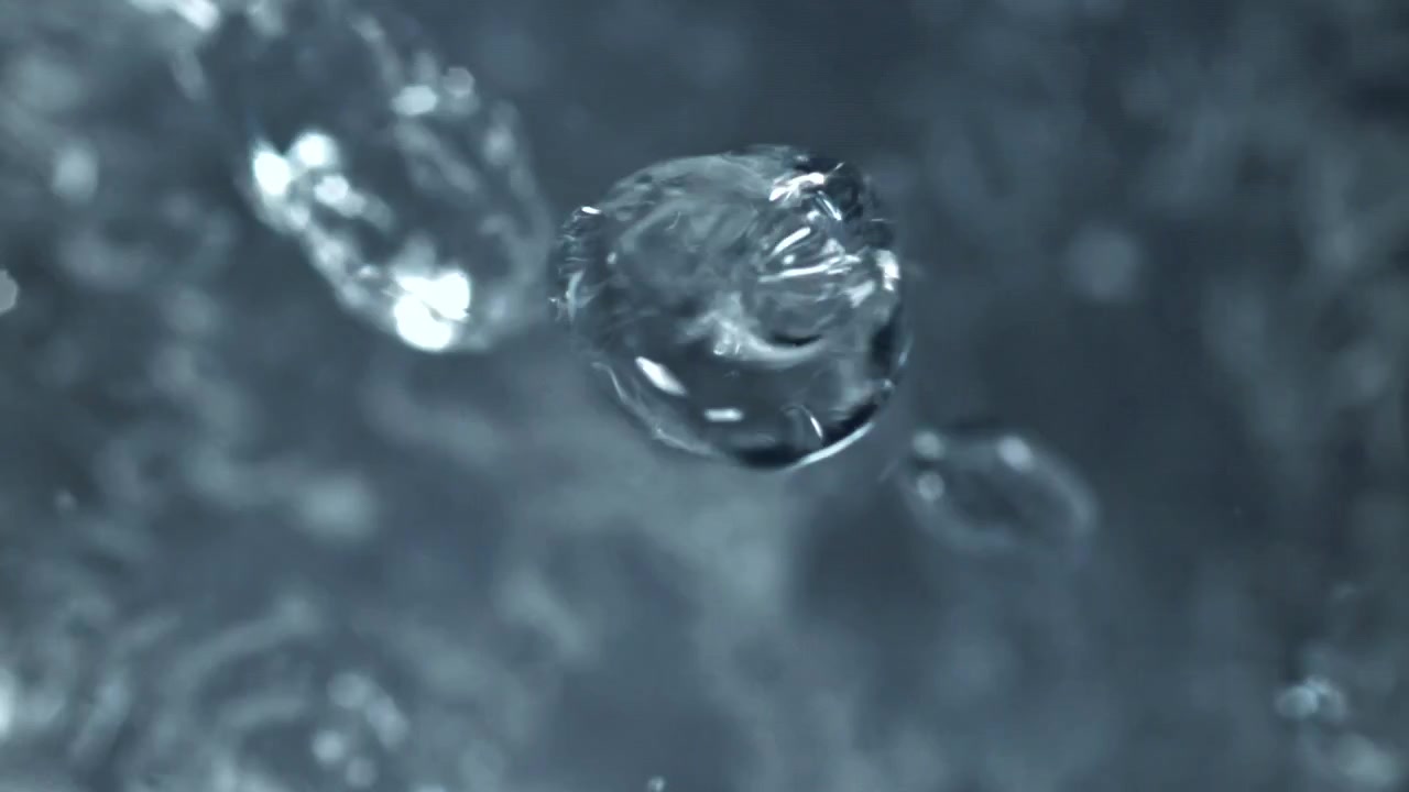 Ripresa macro di gocce d'acqua limpide che cadono al rallentatore