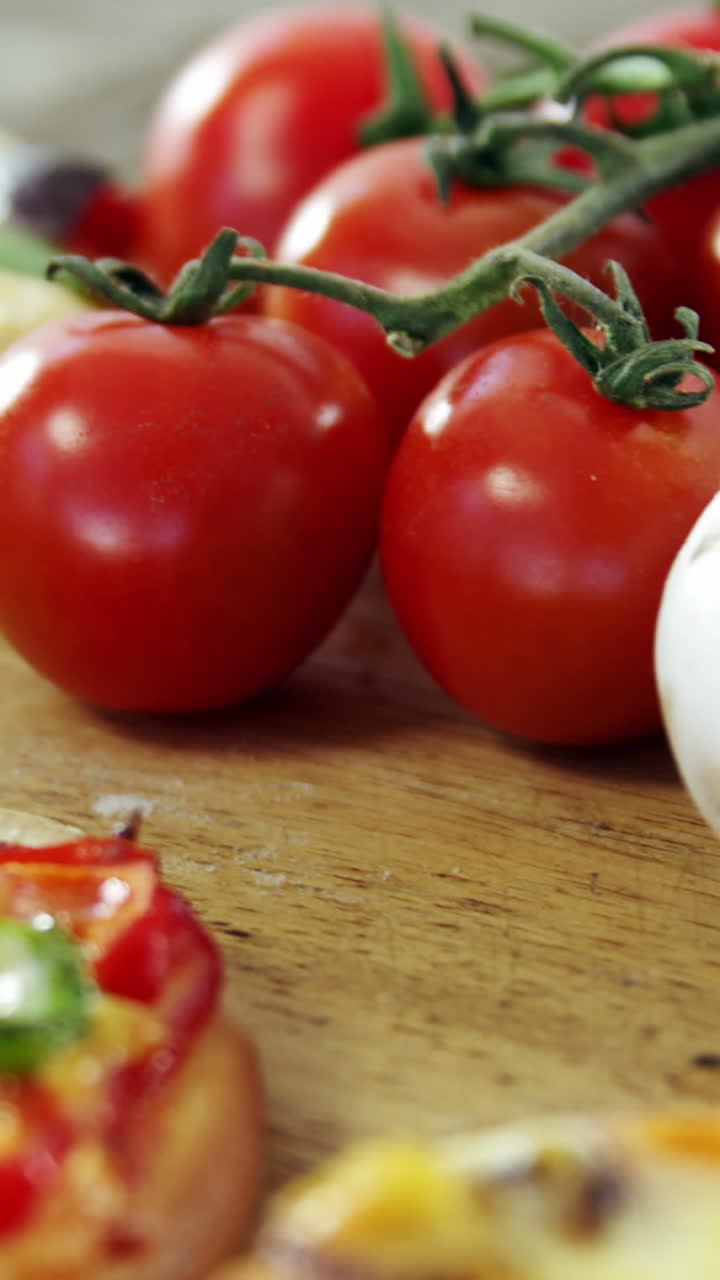 Italian pizza on wooden table with vegetables and spices