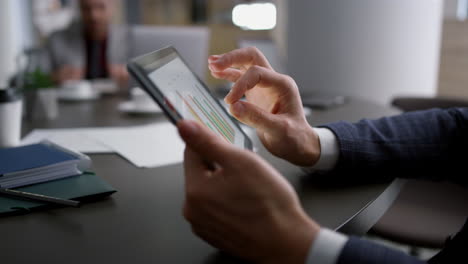 Close-up-view-of-businessman-hands-using-a-tablet