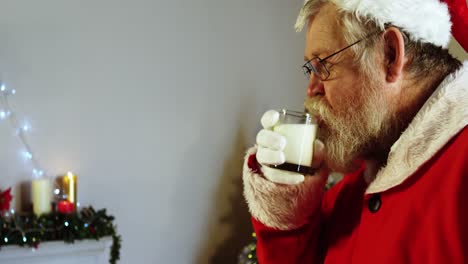 Der-Weihnachtsmann-Entspannt-Sich-Auf-Einem-Stuhl-Und-Trinkt-Milch