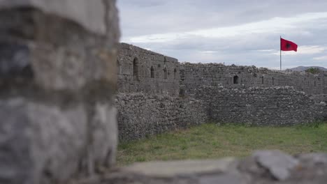 artistic bokeh effect showing albanian flag waving at rozafa castle in soft focus