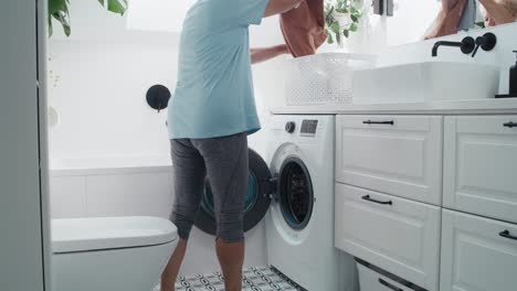 senior caucasian woman cleaning doing laundry in the bathroom