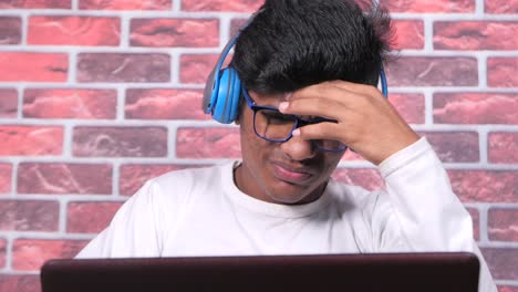 adolescente enfocado trabajando en una computadora portátil con auriculares