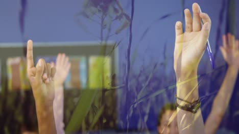 group of students raising hands in class against grass