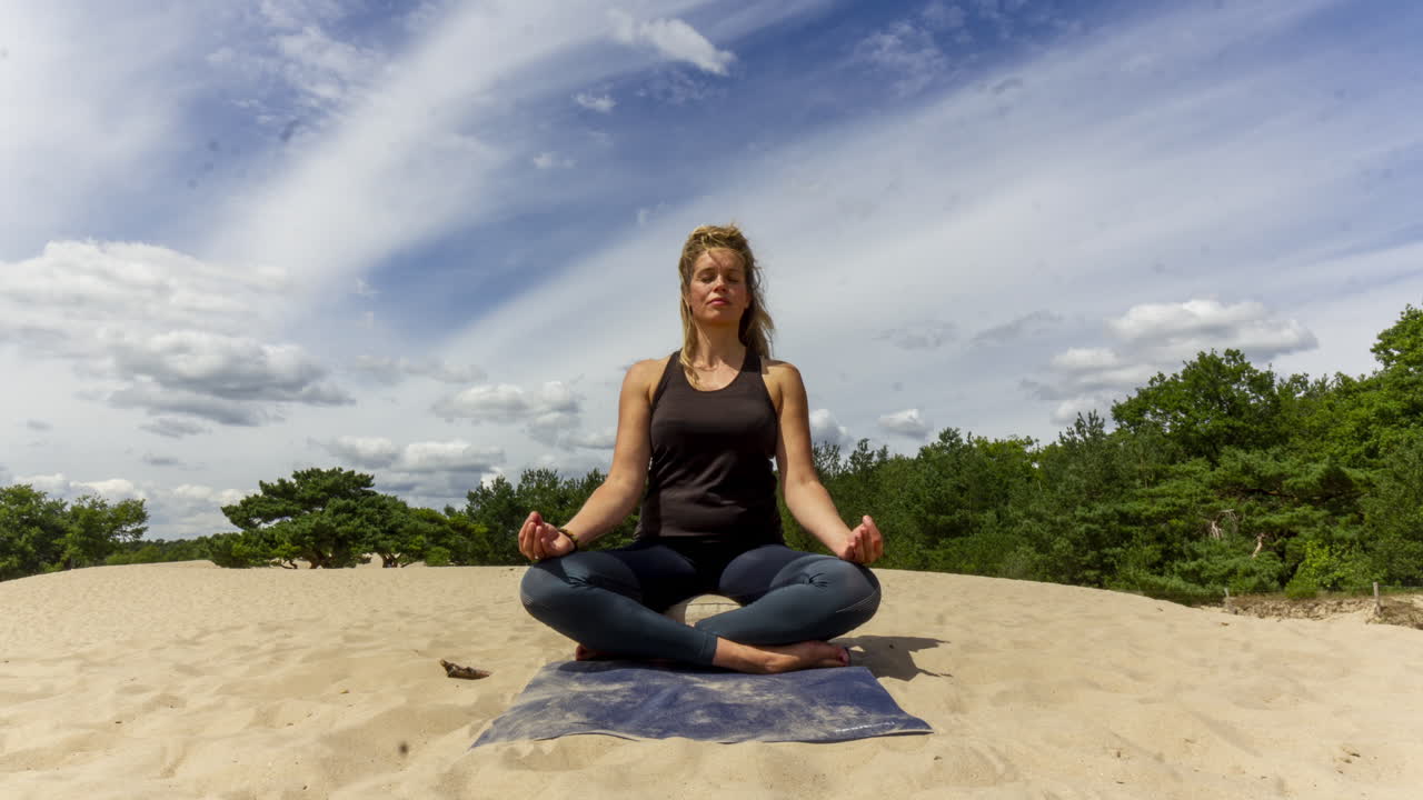 lapso de tiempo de mujer meditando en dunas de arena