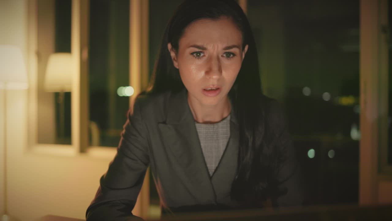 mujer de negocios caucásica trabajando en una computadora portátil tarde en la noche en una oficina oscura con prisa