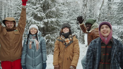 group portrait of happy friends in winter forest