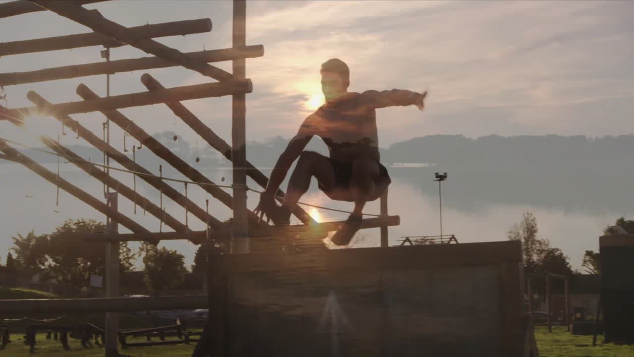 Jumping over obstacle course, person silhouetted against sunset near lake animation