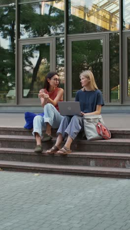 two young women studying outdoors