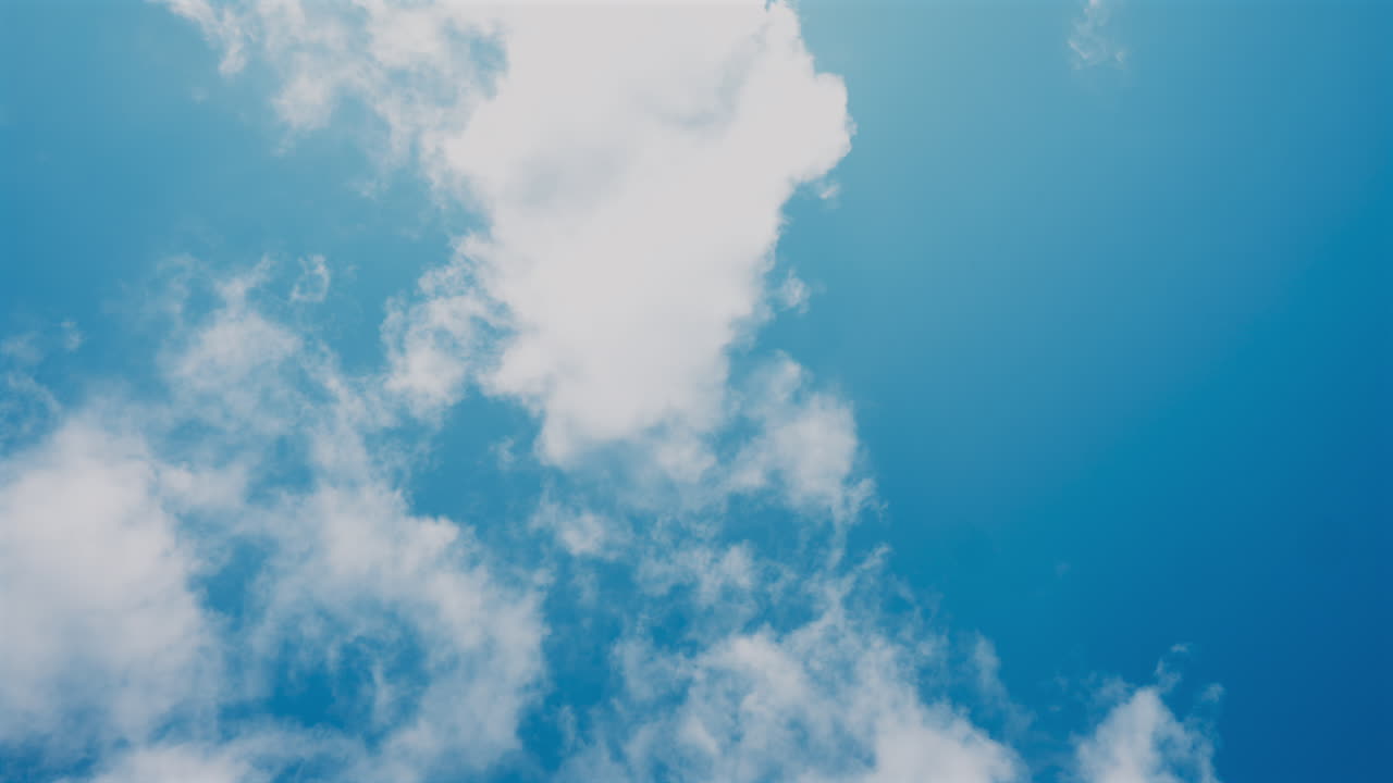 View of white, fluffy clouds moving on the blue sky