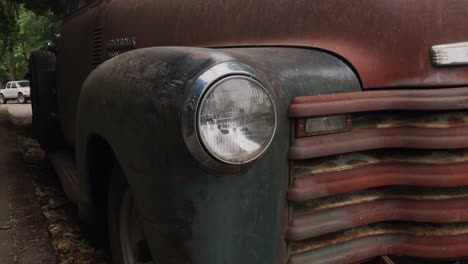 a detail shot of the headlight on a rusty old car