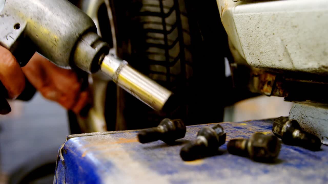 mecánico que usa una máquina de apretar pernos en el garaje 4k