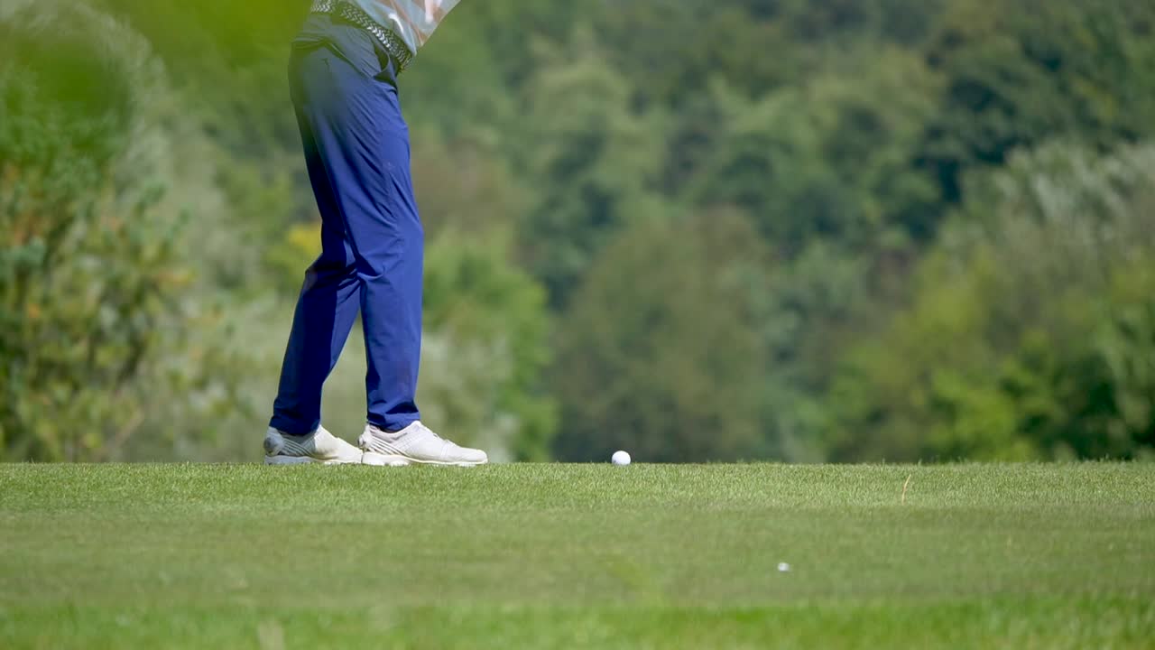 super cámara lenta de golfista de moda golpeando la pelota en el campo de golf bajo el sol - tiro medio de ángulo bajo