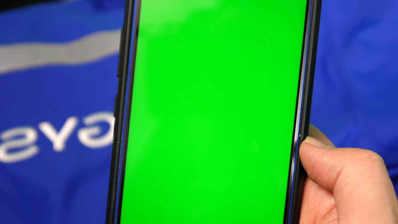 las manos del hombre manipulando el teléfono celular con pantalla verde, croma