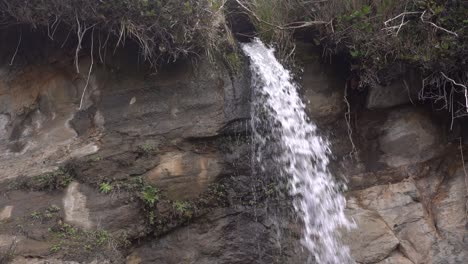 la cascada se derrama en la playa de arena.