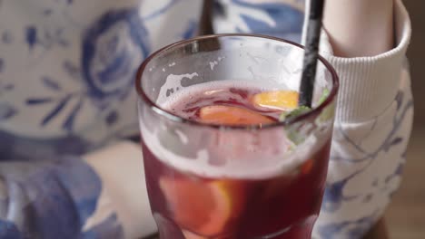 Closeup-of-stirring-a-red-healthy-lemonade-with-a-plastic-straw