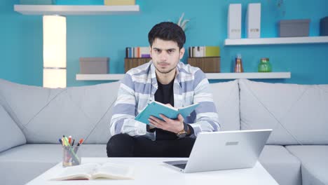 un joven infeliz y aburrido estudiando en casa.