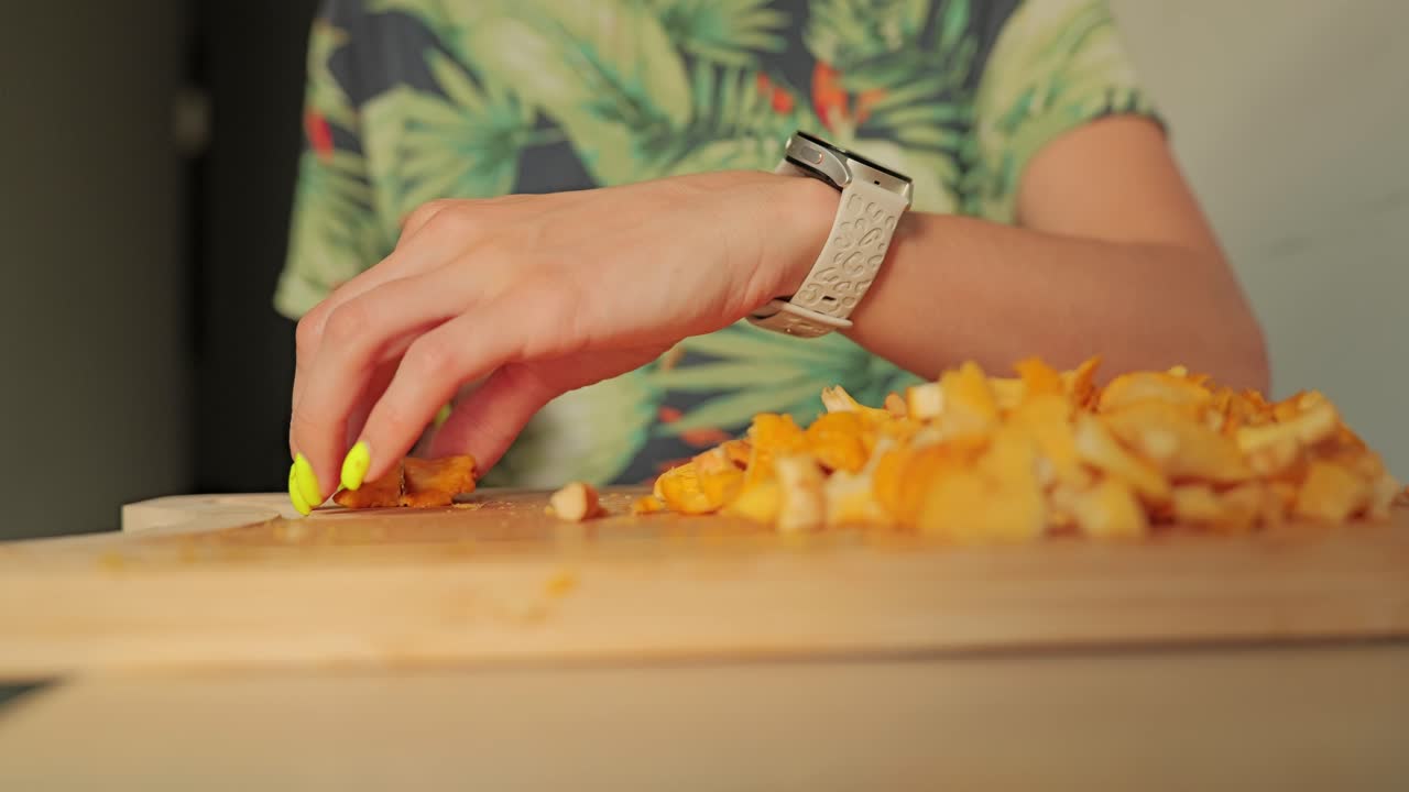 Primo piano delle mani che tagliano funghi finferli durante la preparazione per il raccolto autunnale