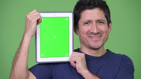 happy hispanic man showing digital tablet