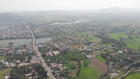 Vista-Aérea-De-La-Ciudad-De-Gingee,-El-Río-Sangarabarani-Y-El-Paisaje-Montañoso-En-El-Fondo-Durante-El-Día-Nublado-Y-Nublado-En-India