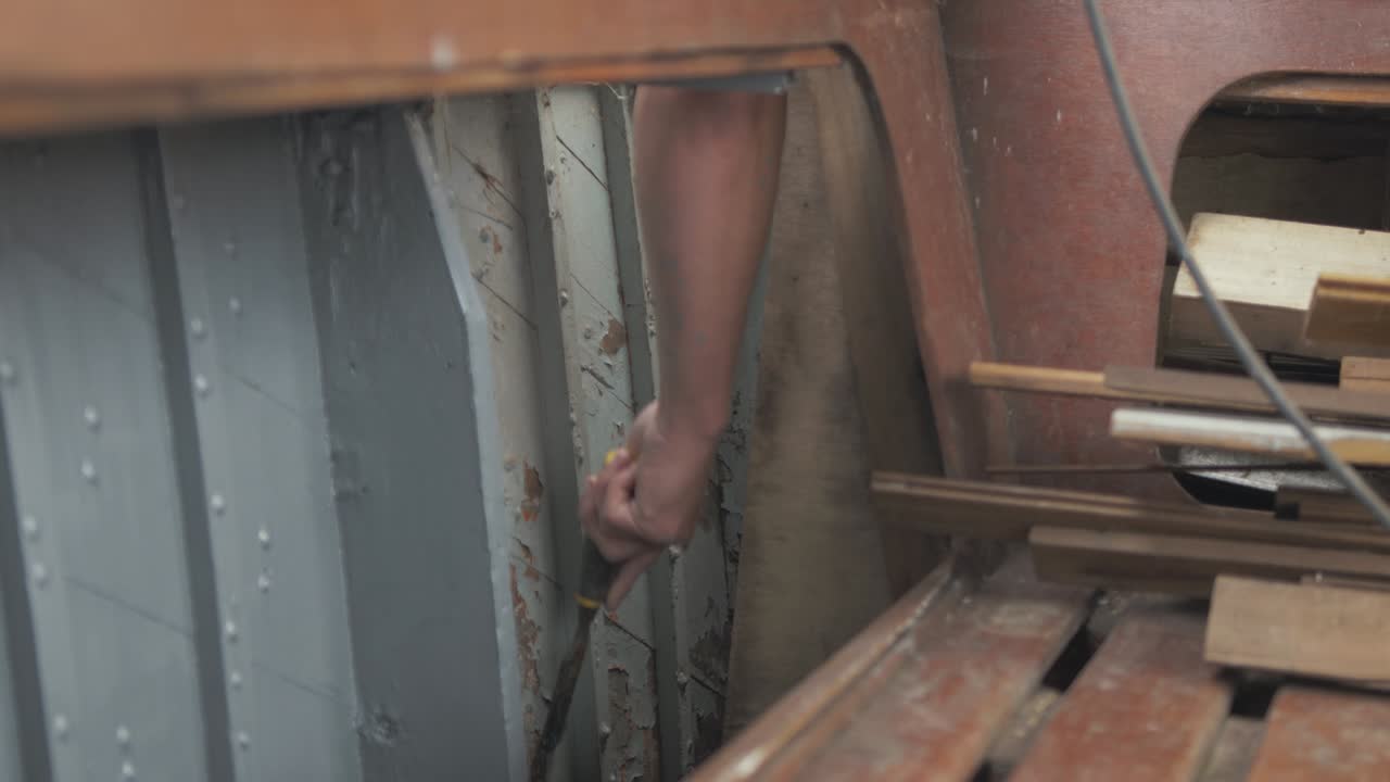 오래된 페인트 보트 내부에서 벗겨지는 남자의 손