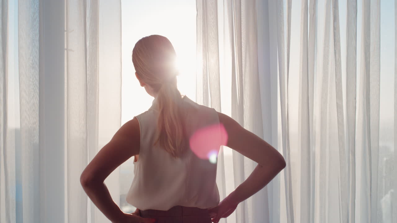 donna d'affari che apre le tende in una stanza d'albergo guardando fuori dalla finestra al fresco nuovo giorno donna indipendente di successo che pianifica l'avvenire all'alba