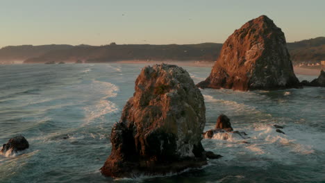 Wide-circling-aerial-shot-of-a-large-sea-stack-surrounded-by-sea-birds