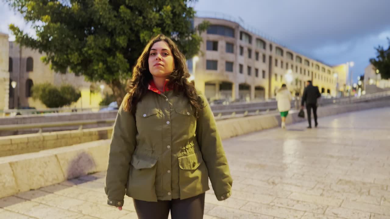 Una donna cammina lungo un marciapiede in città