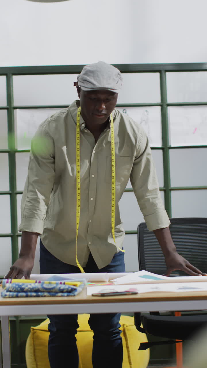 Video verticale di un designer uomo afroamericano che lavora in ufficio.