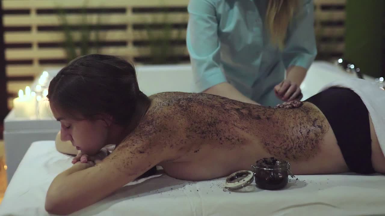 Woman receiving a back scrub at a spa