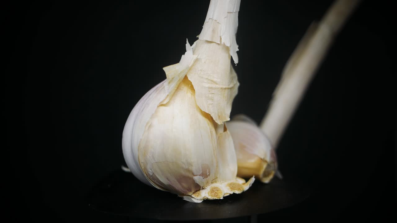 스튜디오의 검은색 배경에서 회전하는 신선한 마늘 정향 - 가까이