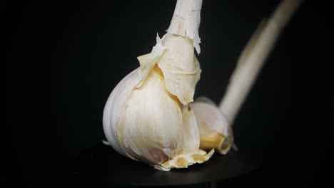 Frische-Knoblauchzehen-Rotieren-Auf-Schwarzem-Hintergrund-Im-Studio---Nahaufnahme