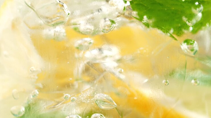Lemonade In A Glass - Air Bubbles Squeeze Between The Lemon Slices, Ice And Mint in Macro and Slow Motion