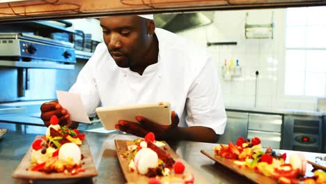 chef looking at order list while using digital tablet at order station