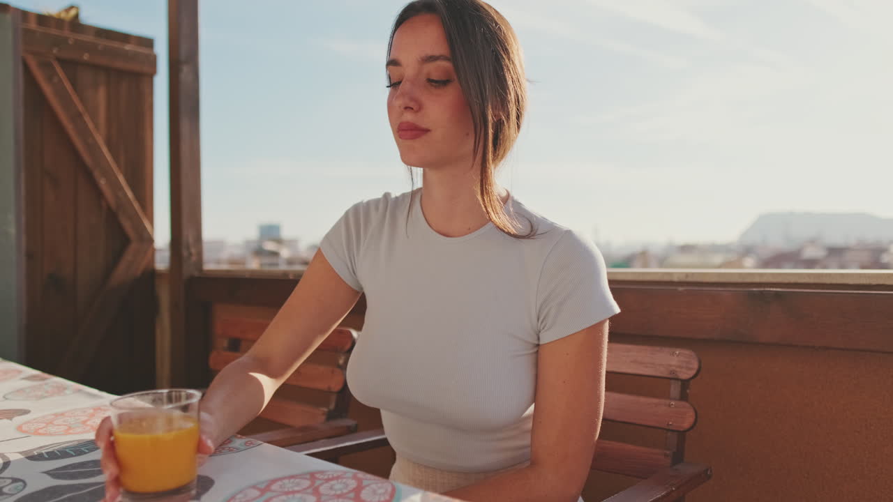 Woman enjoying morning on balcony with orange juice